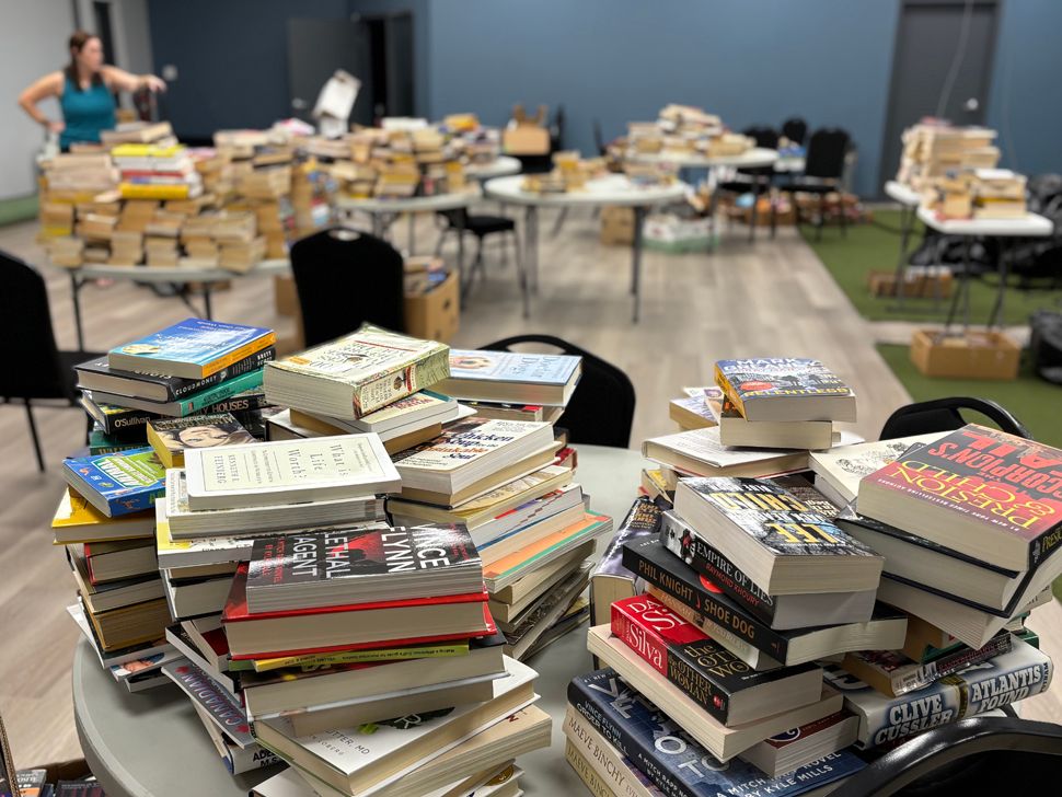 Tables piled high with books being sorted for Niverville Lending Library.